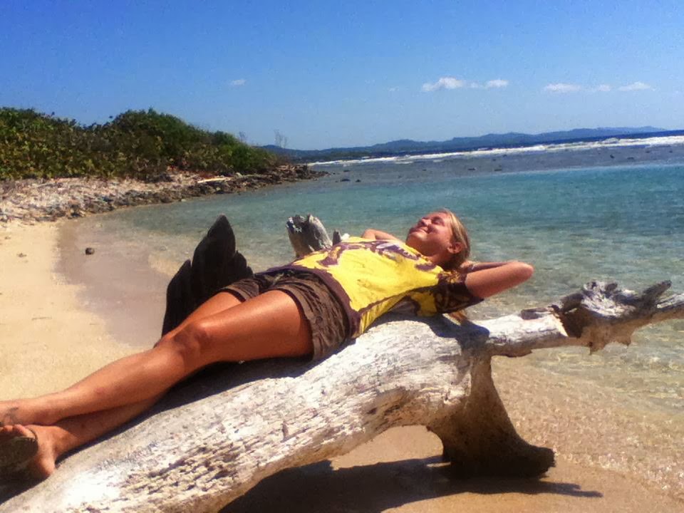 Me lounging on a piece of driftwood in Roatan, Honduras