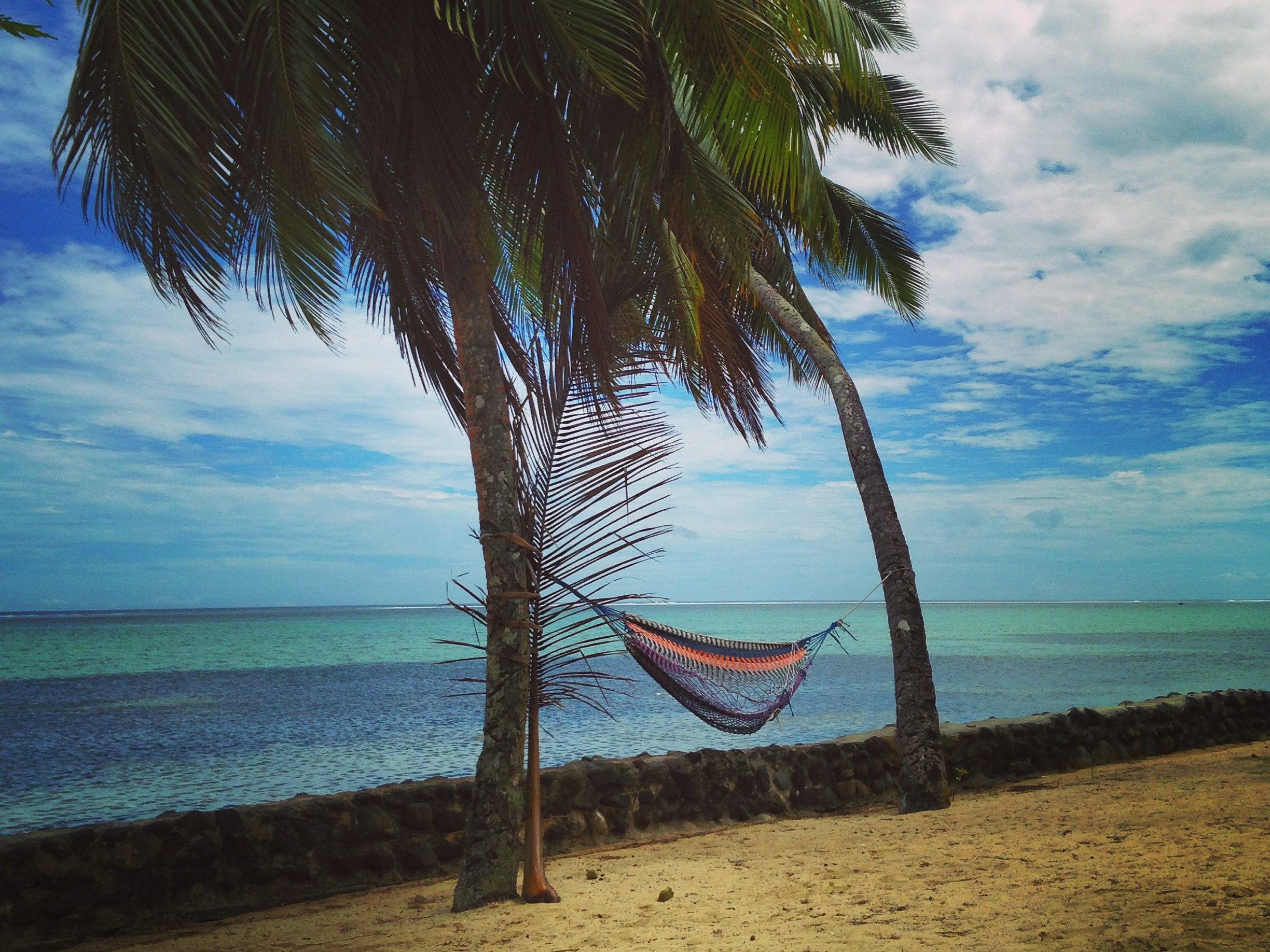 Hammock hanging between two trees on the beach